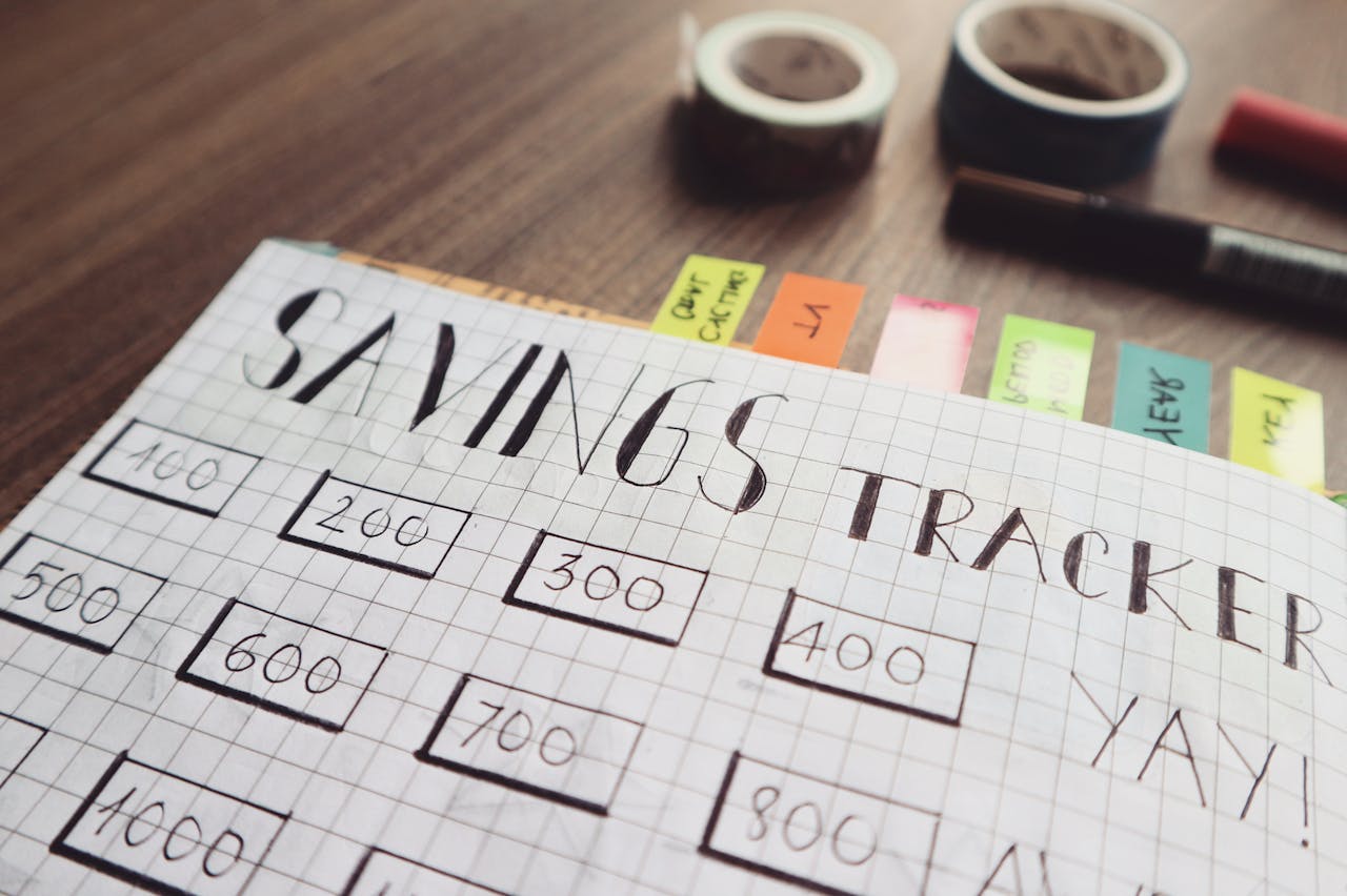 cta-bg Close-up of a handmade savings tracker with colored tabs on a wooden table, ideal for financial planning visuals.
