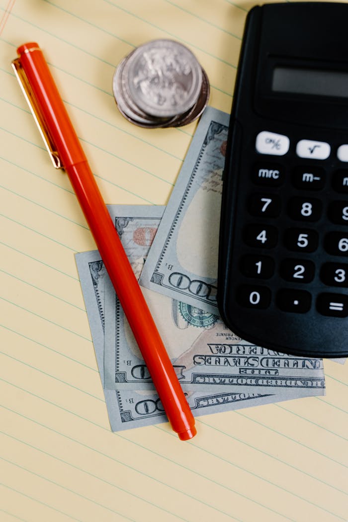 home-services-03 Close-up of a pen, calculator, and cash on a notepad, representing financial planning.